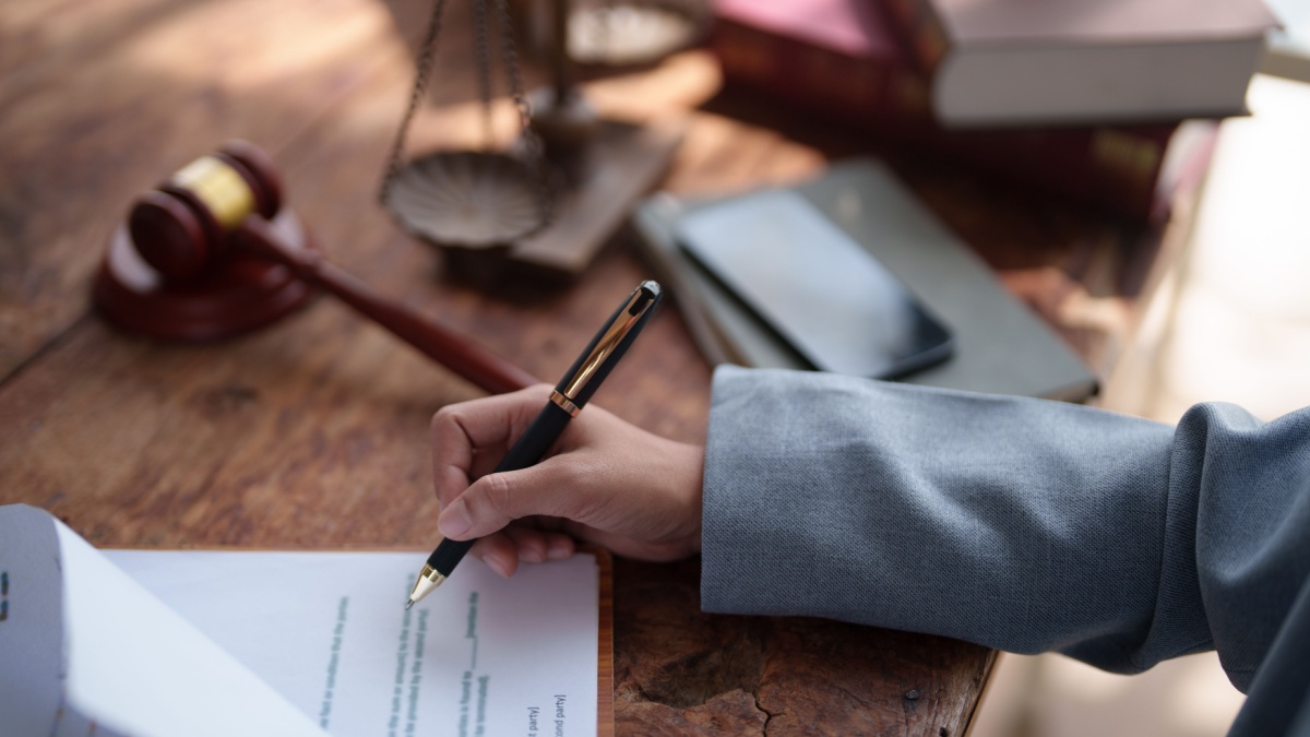 Mano che firma e strumenti del giudice 